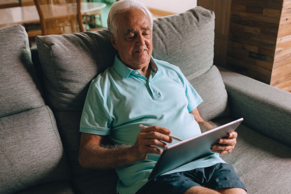 Senior checking SilverSneakers eligibility on a tablet using their Medicare plan card
