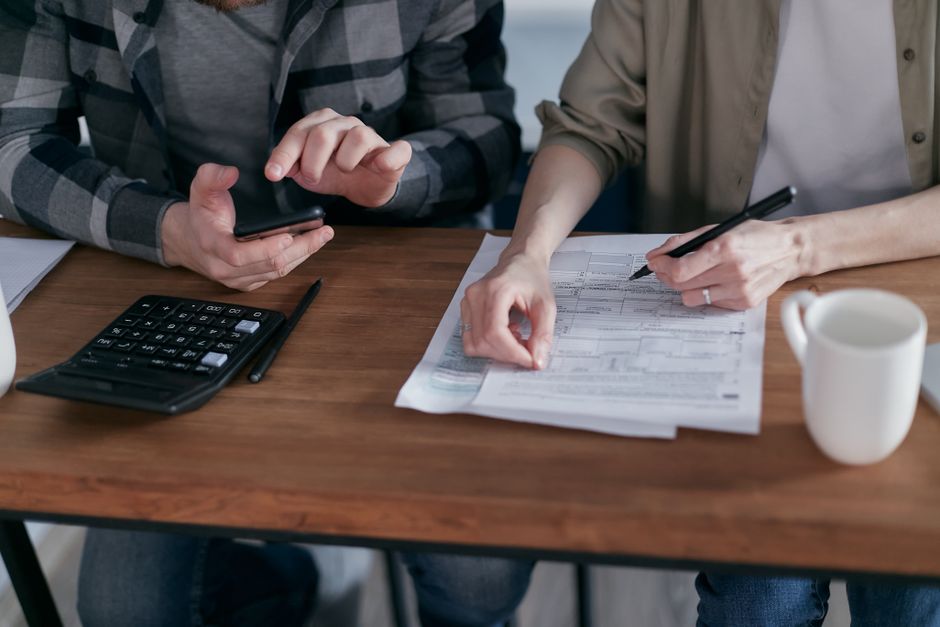 Taxpayer reviewing Form 8839 and a calculator while preparing a return