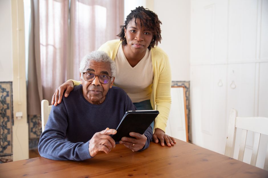 Adult child helping elderly parent review tax paperwork