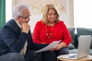 Retired couple reviewing bank fees on a statement at home