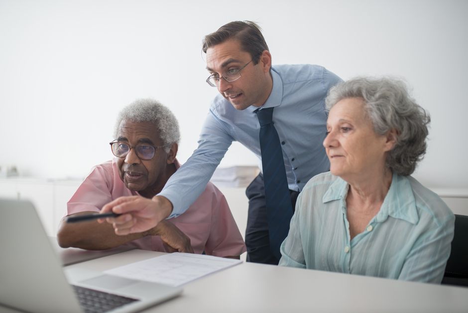 Couple reviewing paperwork and financial documents at the kitchen table to figure out home sale capital gains