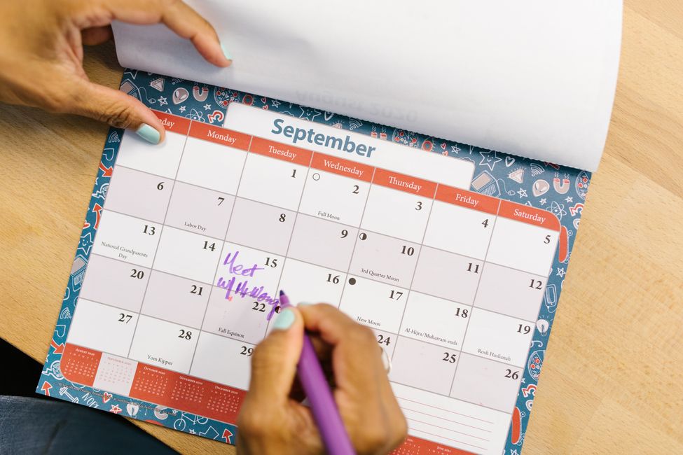 Hand marking CPP payment dates on a calendar while comparing early versus delayed retirement options