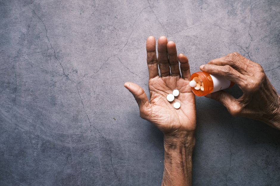Close-up of a retiree reviewing prescription costs and a medical bill
