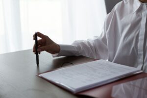 Adult reviewing a funeral price list document at a table