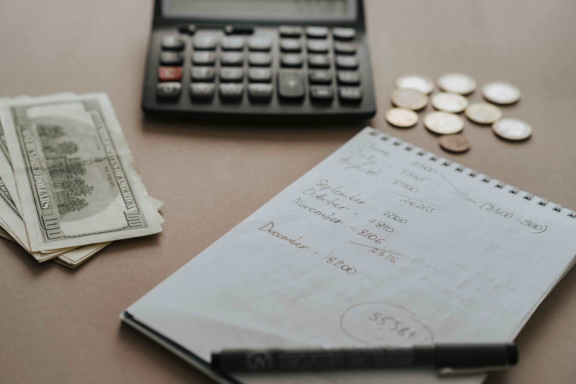 Canadian currency and calculator representing GIS monthly payment calculations