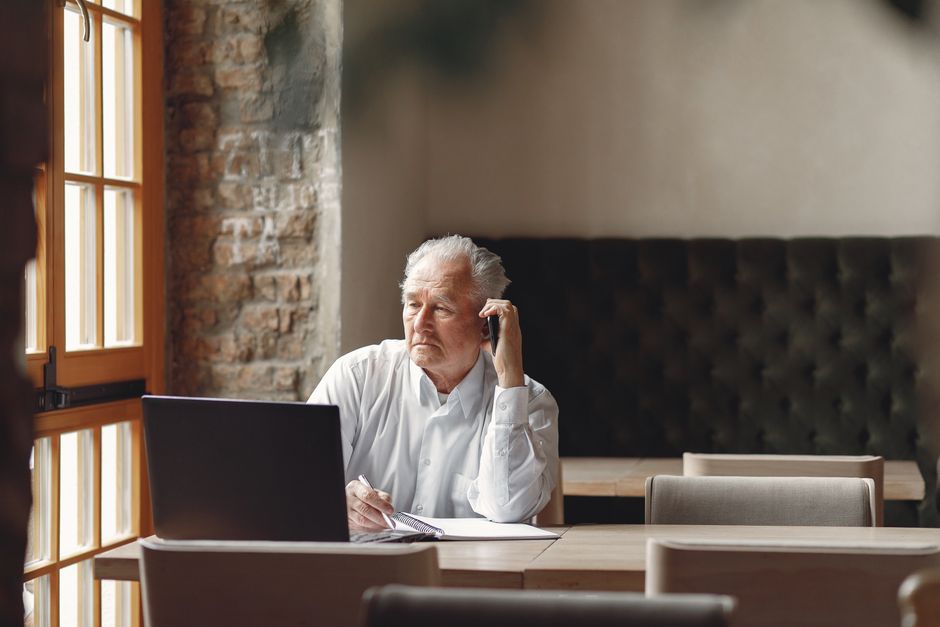 Senior homeowner taking notes during a HUD-approved HECM counseling call