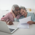 Joyful senior couple reviewing a life insurance policy document at home