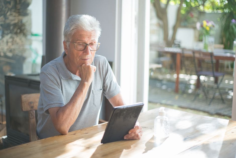 Senior comparing Medicare Advantage plan benefits and costs on a tablet checklist