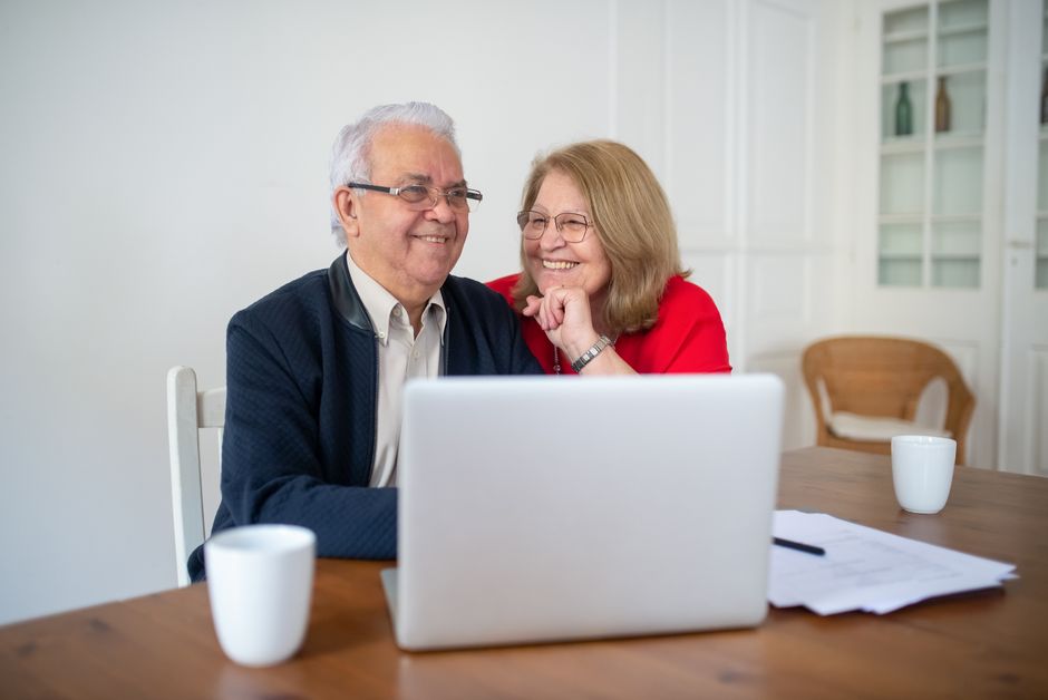 Couple comparing Medicare Part D plans online during open enrollment