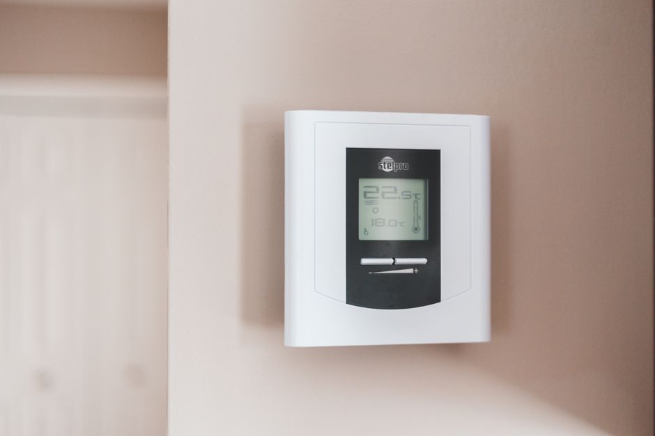 Home thermostat and utility bills representing LIHEAP energy assistance