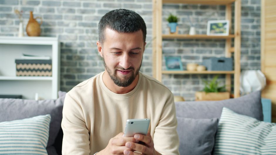 person checking a benefits application on a phone at home