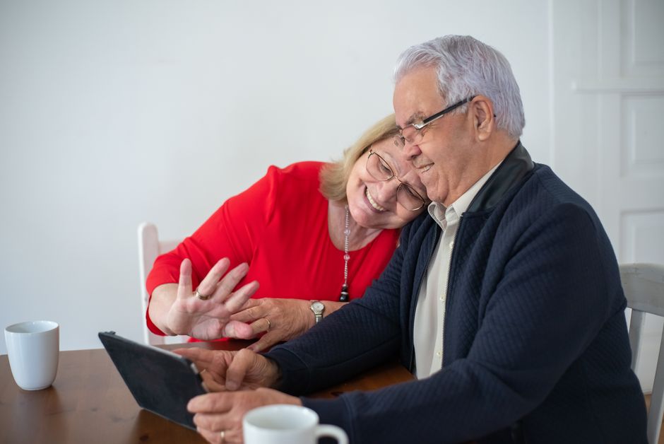 older couple using a tablet to video call family members at home
