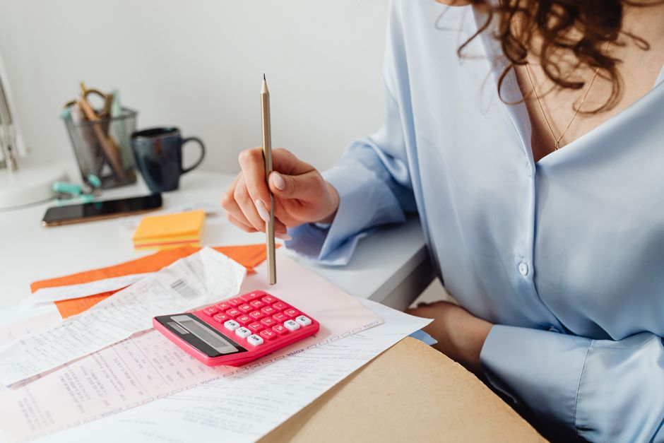 person using a calculator to work out retirement account withdrawal amounts