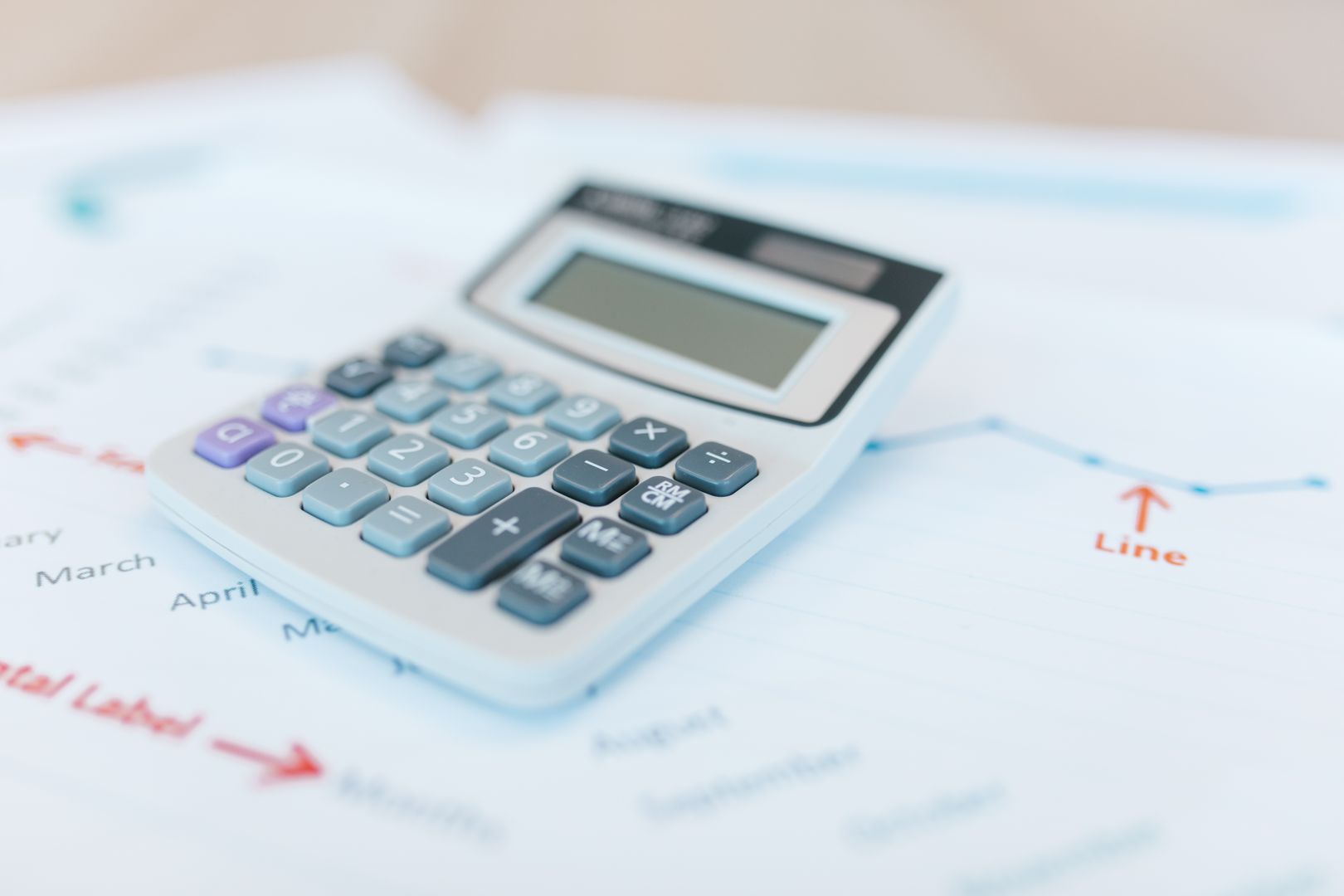 Close-up of calculator and savings growth chart on a desk