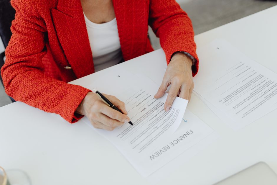 Person writing a check for charitable giving next to retirement paperwork