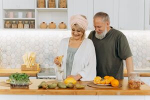 older adult organizing meal prep containers at the kitchen table on a fixed income