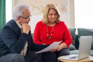 Older Canadian reviewing disability tax credit paperwork at a kitchen table