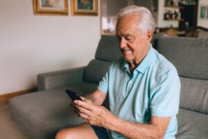 Senior adult reviewing a cell phone bill on a smartphone at home