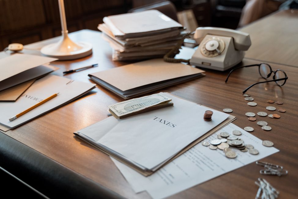 Desk with paperwork and coins showing income and resource limit calculations for SSI eligibility