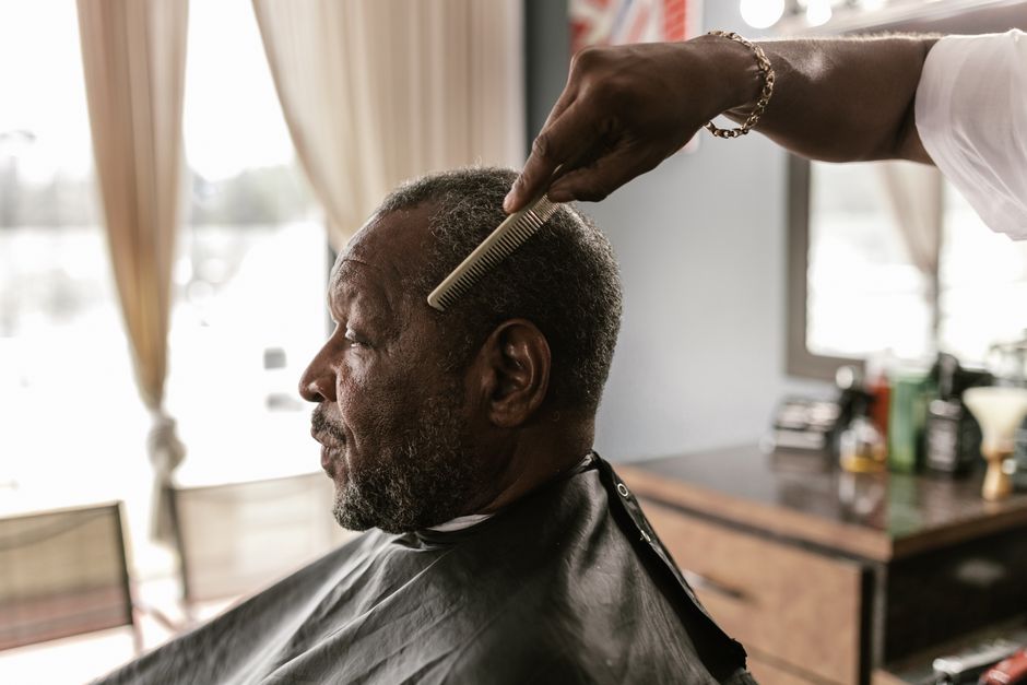 Senior man getting a haircut with a smile at a local barbershop