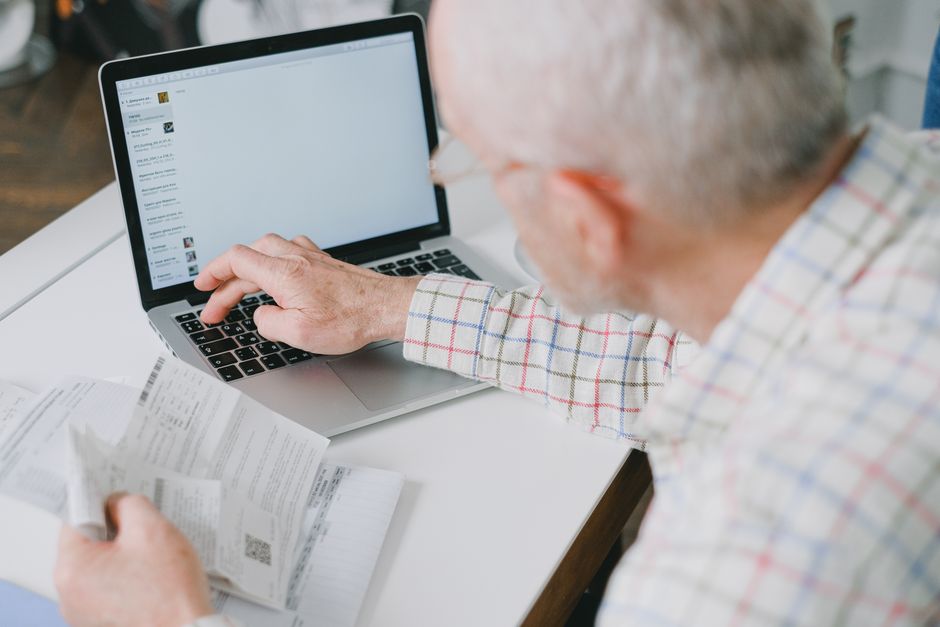 Senior man checking AARP membership discounts online to decide if it's worth the cost