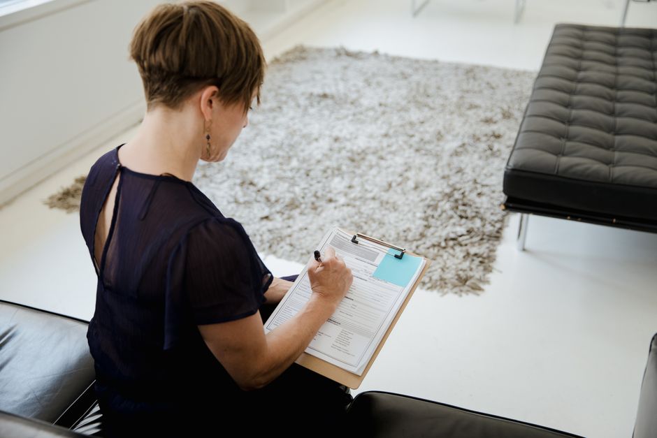 Applicant filling out housing assistance paperwork on a clipboard