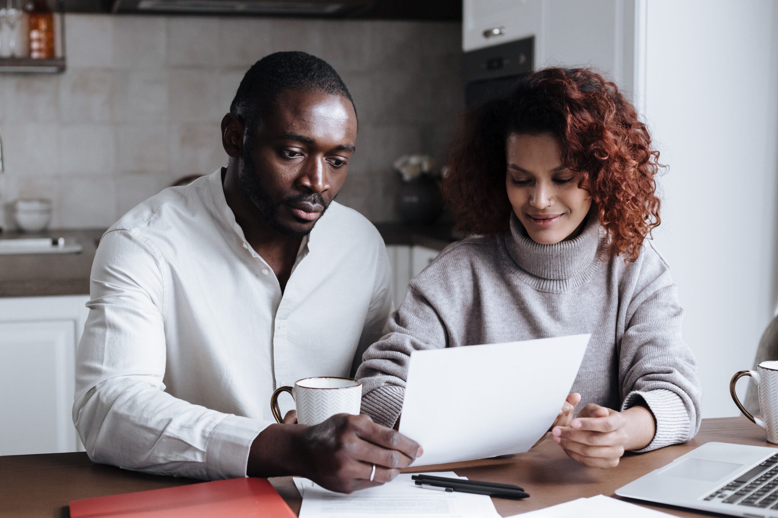 Canadian couple in their early 60s reviewing benefit paperwork at home