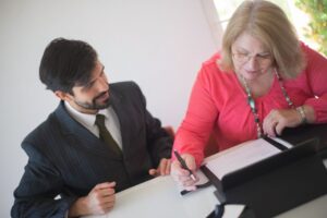Adult daughter helping her senior mother review Canada Caregiver Credit paperwork at home