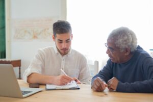 Adult child reviewing tax paperwork with an elderly parent at home