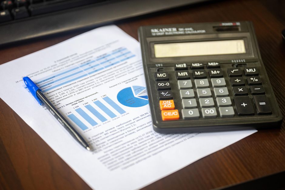 Close-up of estate planning documents, a calculator, and a pen on a desk