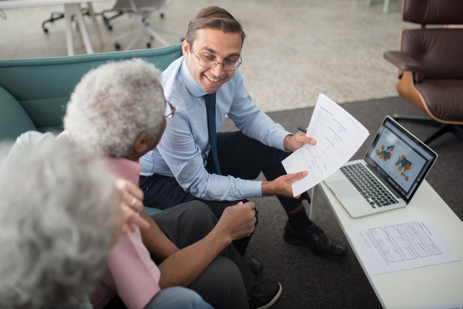 Retired couple reviewing estate planning documents with a financial advisor