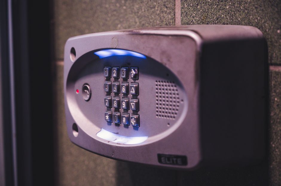 close-up of home security keypad and smoke detector installed for insurance safety discounts
