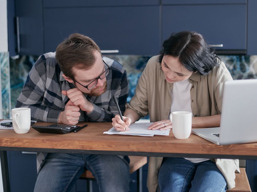 Couple comparing 2026 self-only and family HSA contribution limits at the kitchen table