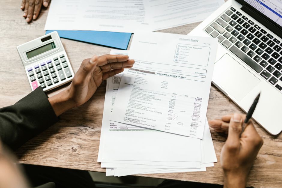 Close-up of hands comparing Medigap insurance quotes from multiple companies on a laptop with a calculator