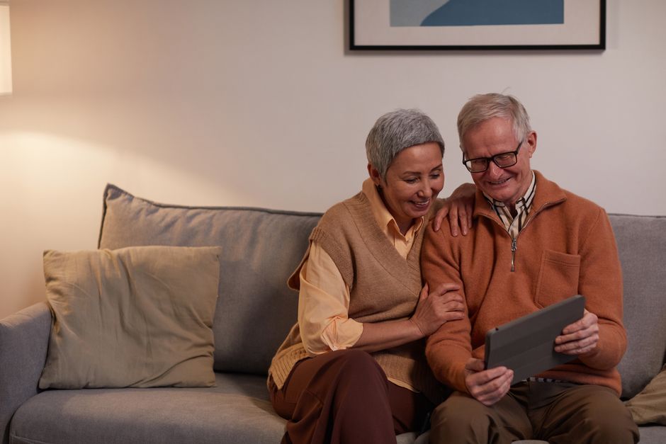 Happy retired couple confirming their Medigap plan decision on a tablet in a bright living room