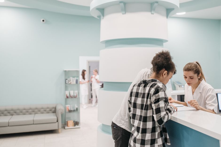 Senior patient confirming Medicare assignment and coverage details at a doctor's office front desk