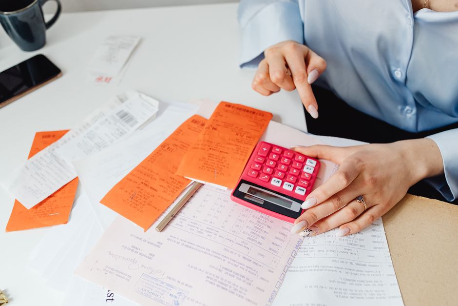 close-up of a grocery receipt and calculator being used to compare delivery service costs