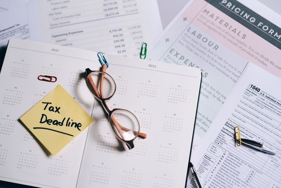 Tax filing deadline marked on a calendar next to IRS tax forms