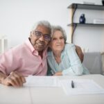 Senior couple reviewing a property tax bill and paperwork at their kitchen table