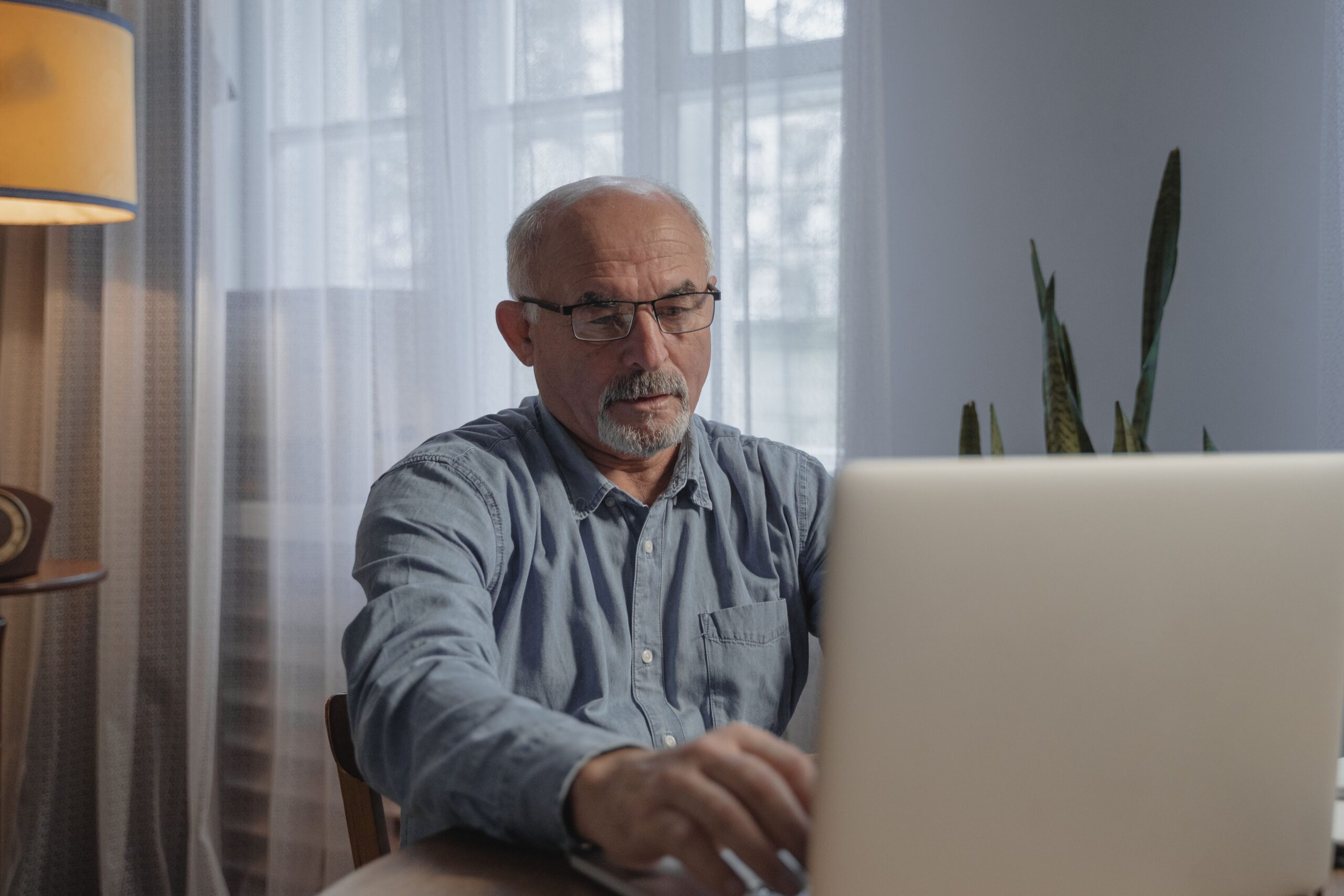 Senior using a laptop to log into My Service Canada Account to apply for the Allowance