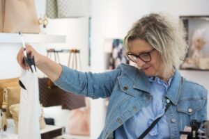 Senior shopper browsing clothing racks at a department store