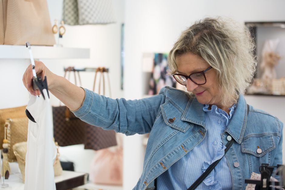 Senior shopper browsing clothing racks at a department store
