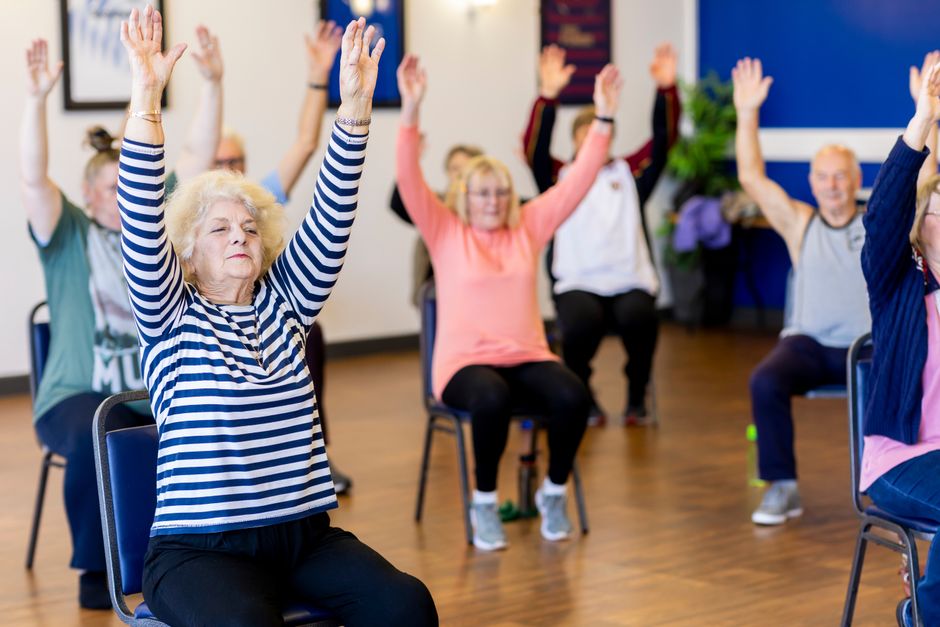 Older adults participating in a free chair yoga or memory cafe program at a public library