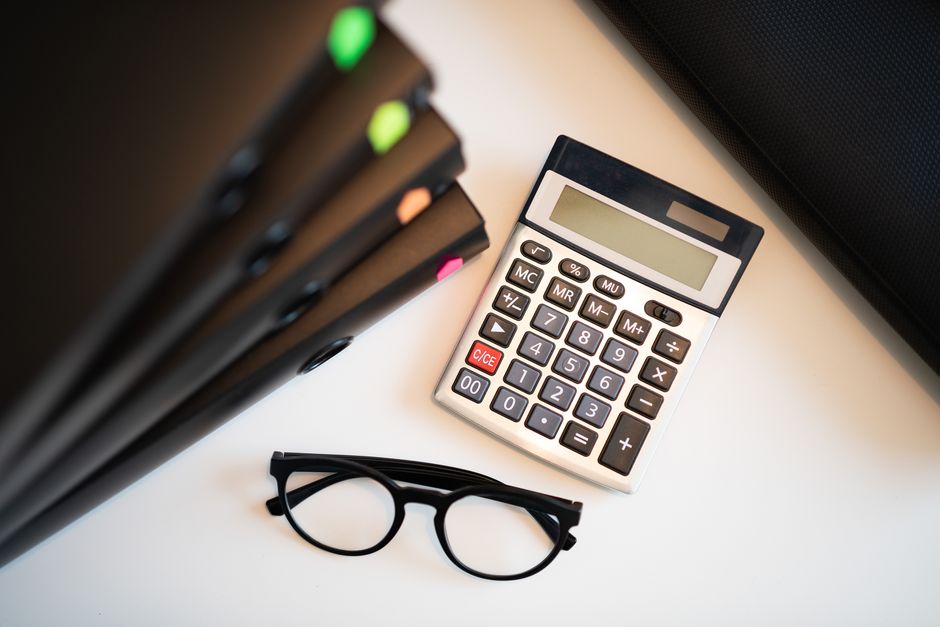 Calculator and Social Security paperwork used to estimate survivor benefit percentages