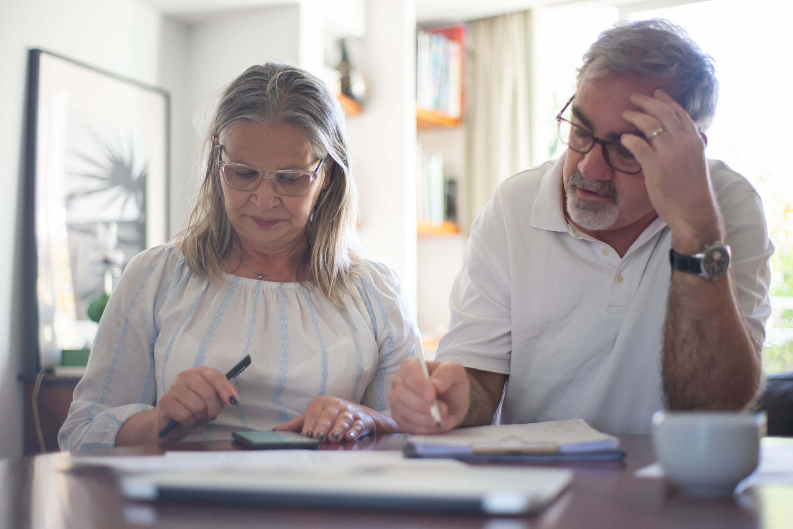 Senior reviewing a budget billing statement with a calculator