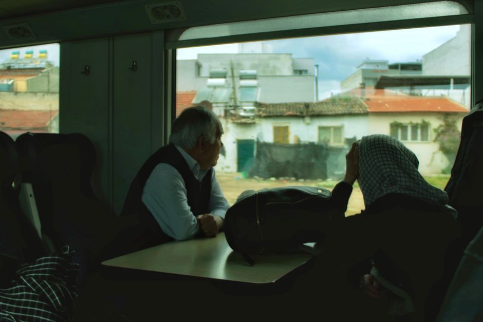 Senior passenger looking out the window from a train seat