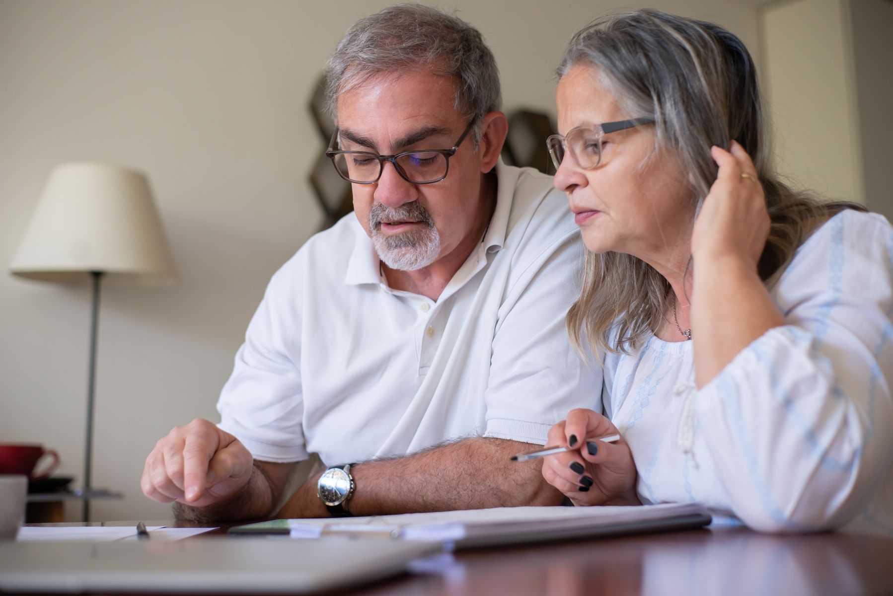 Retired couple doing a crossword puzzle together at home