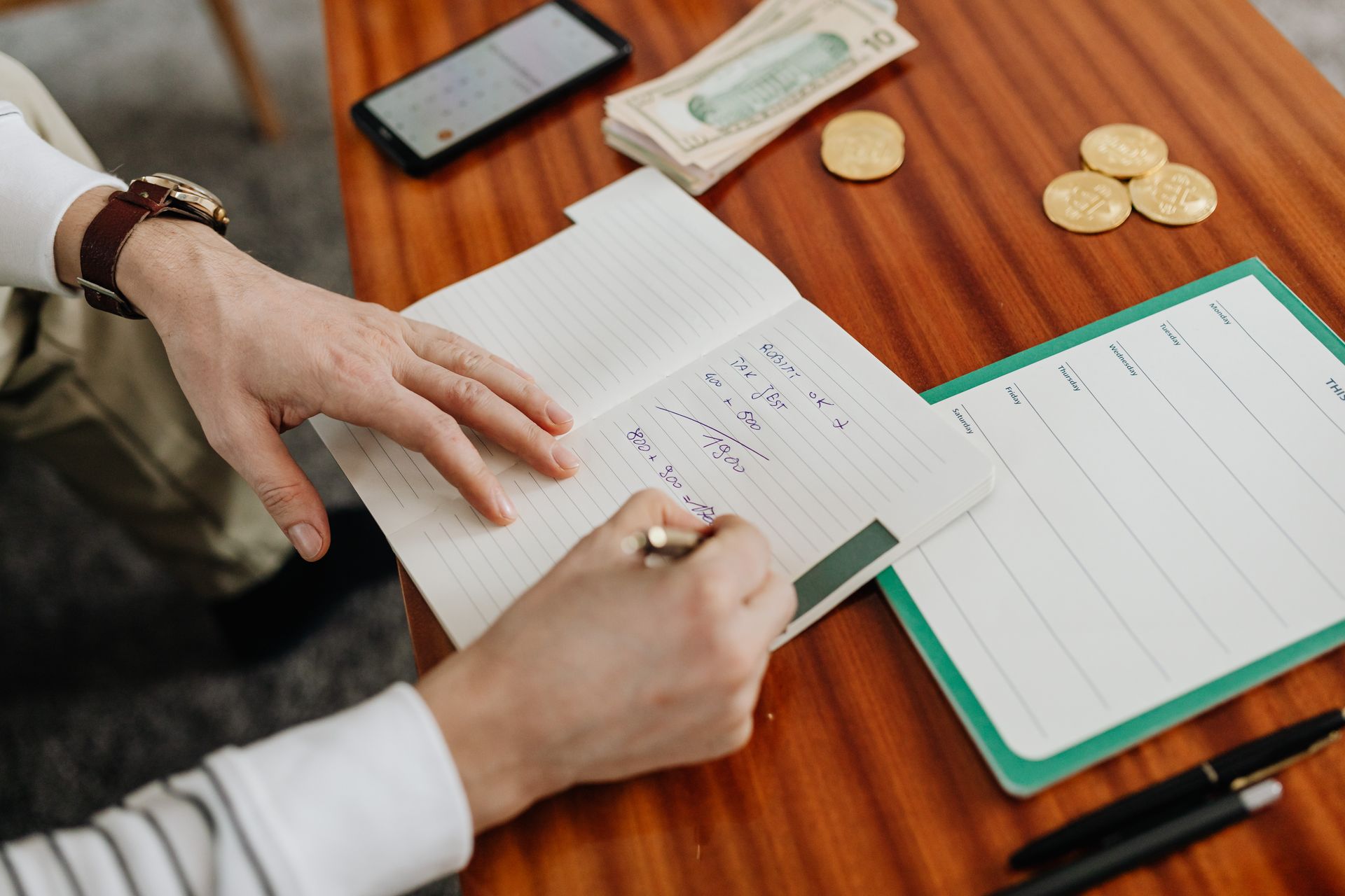 Handwritten list of debts, balances, and interest rates used to plan a payoff strategy