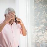 Senior man on the phone looking concerned while talking to a timeshare exit company