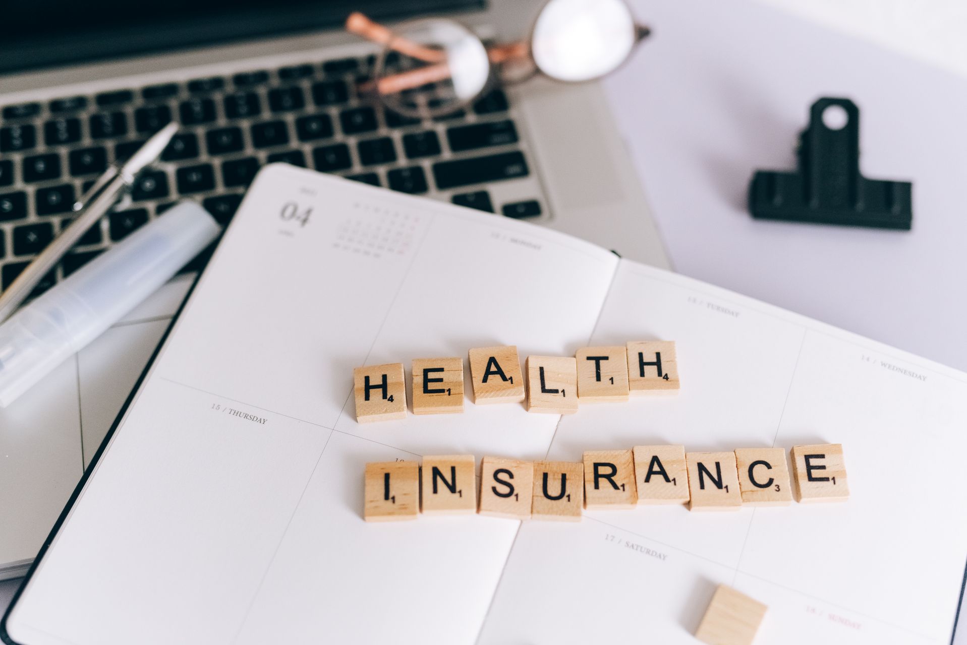 Health insurance paperwork and laptop for marketplace enrollment after divorce
